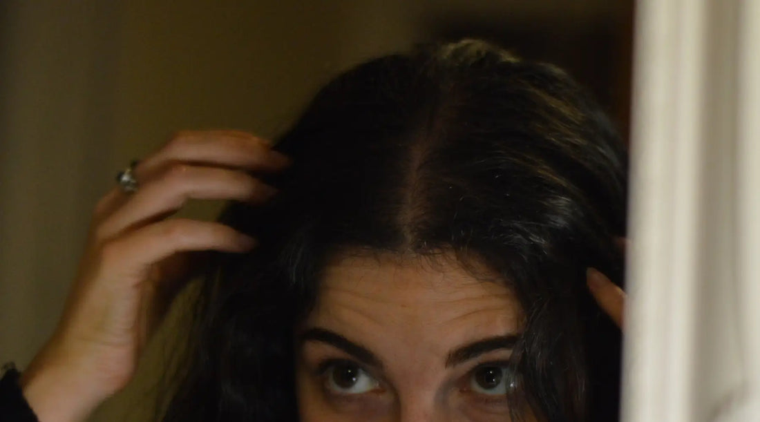 Person checking scalp and hair roots to monitor hair growth and scalp health