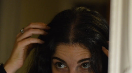 Person checking scalp and hair roots to monitor hair growth and scalp health